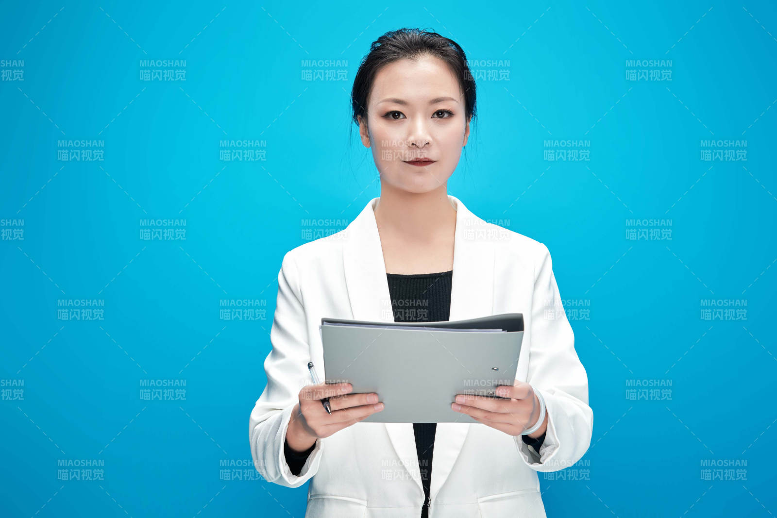 身穿西服拿着手机与文件夹的亚洲商务女士图片