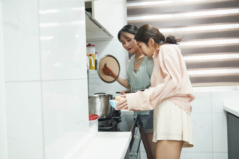 在厨房烹饪美食的亚洲闺蜜少女图片