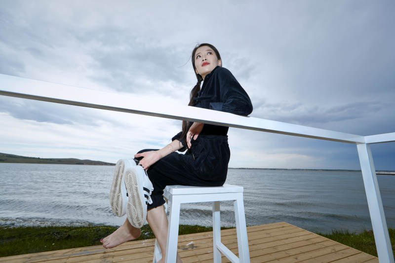 悠闲的坐在美丽湖岸码头的长发少女图片