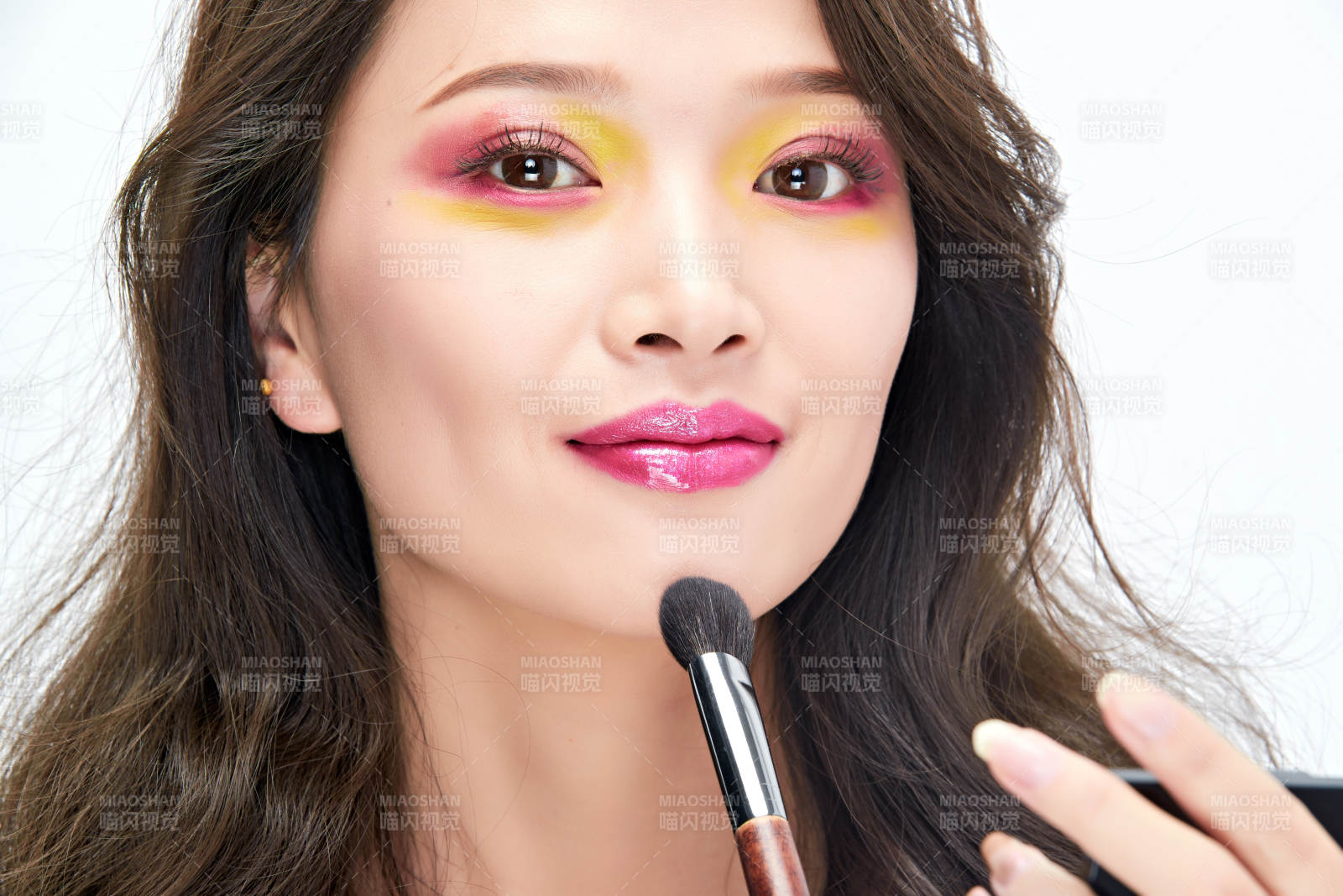 白色背景下棚拍化妆中的美女图片