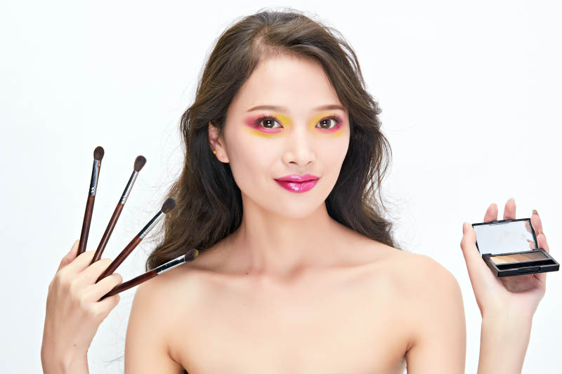 白色背景下棚拍化妆中的美女图片