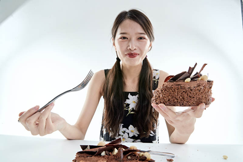 喝红酒品尝蛋糕的年轻女性图片