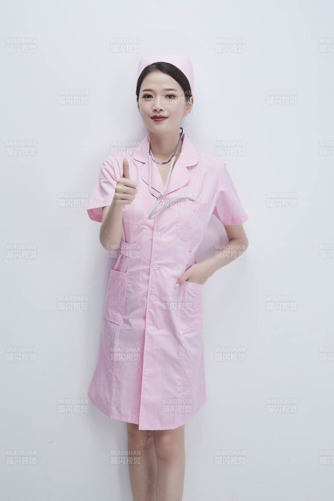 身穿粉色护士服佩戴听诊器的女性医护人员图片