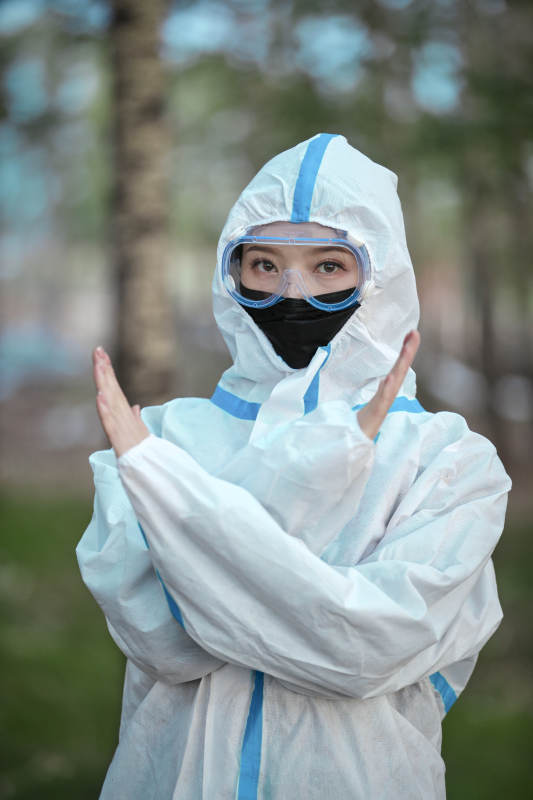 穿白色防护服佩戴护目镜口罩的女性防护人员图片