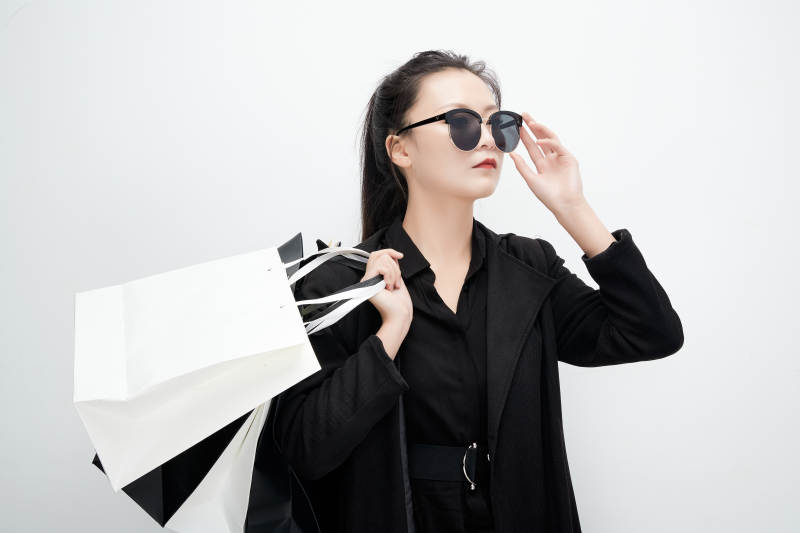 白色背景下手提购物袋时尚美丽的亚洲少女图片