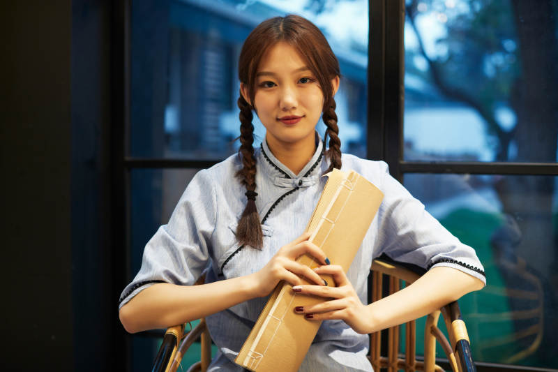 室内手拿老旧报纸的民国风少女图片