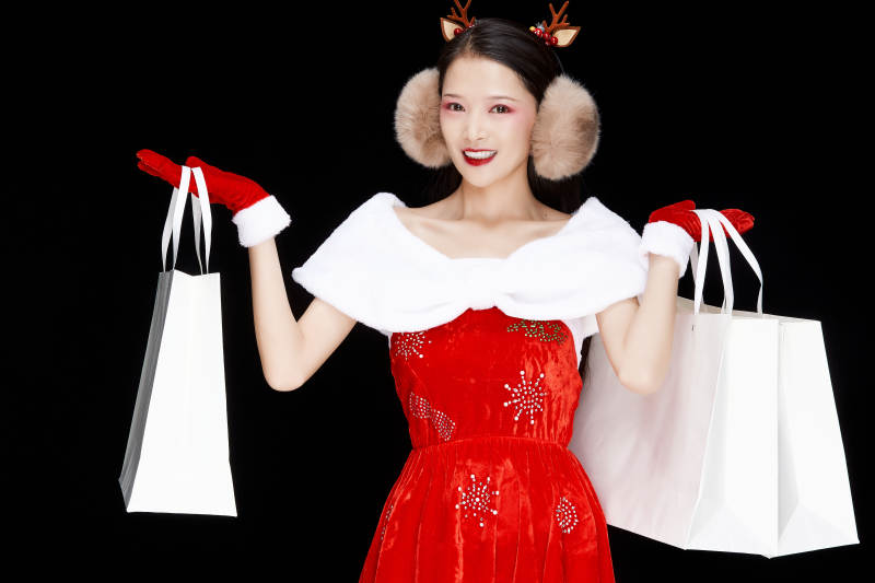 身穿圣诞服饰手提购物袋性感可爱的圣诞女郎图片