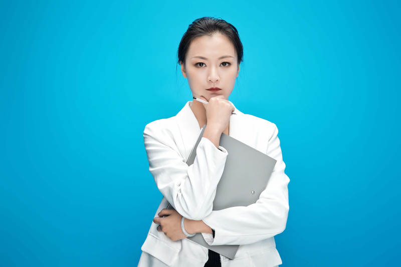 身穿西服拿着手机与文件夹的亚洲商务女士图片