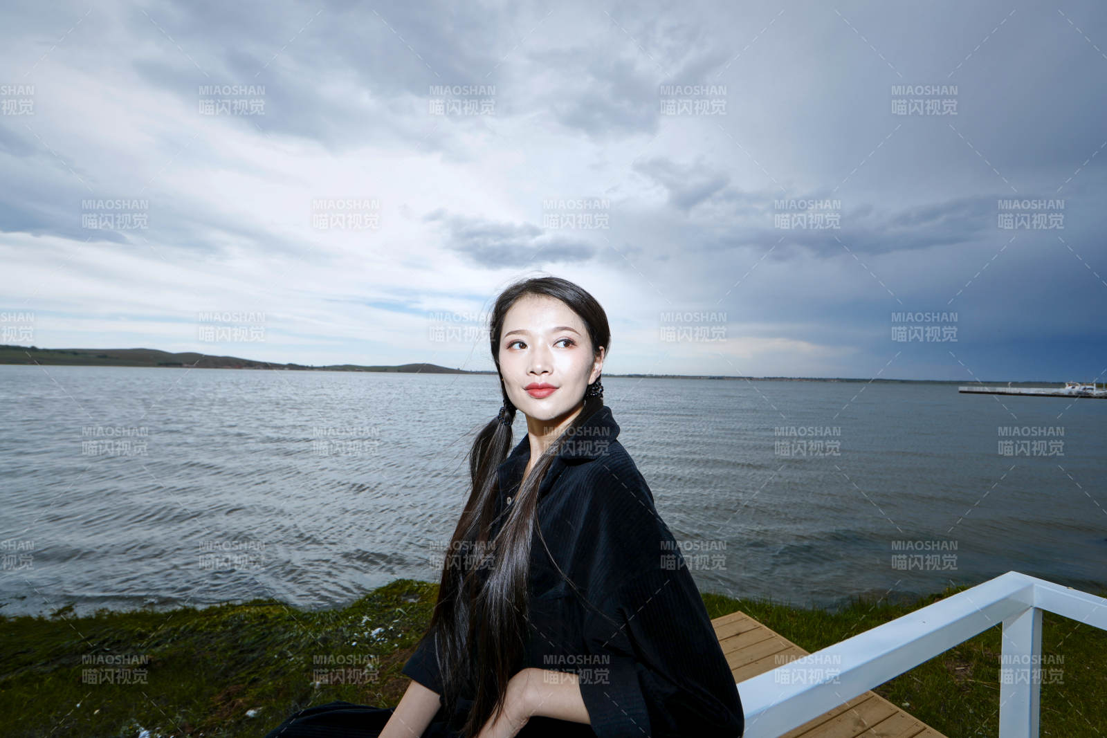 悠闲的坐在美丽湖岸码头的长发少女图片