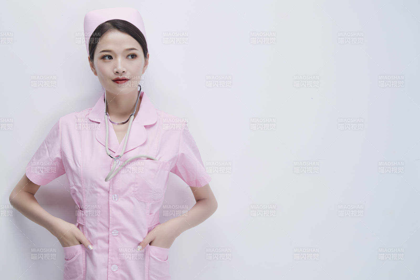 身穿粉色护士服佩戴听诊器的女性医护人员图片