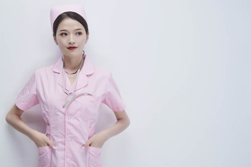 身穿粉色护士服佩戴听诊器的女性医护人员图片