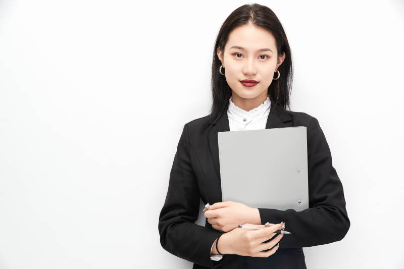 身穿西服拿着文件夹的美丽商务女士图片