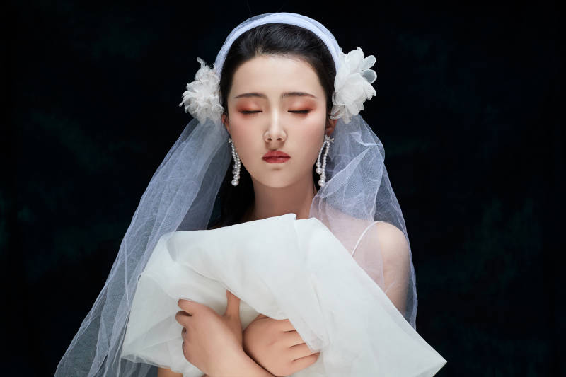 黑色背景下的女性复古婚纱妆面图片