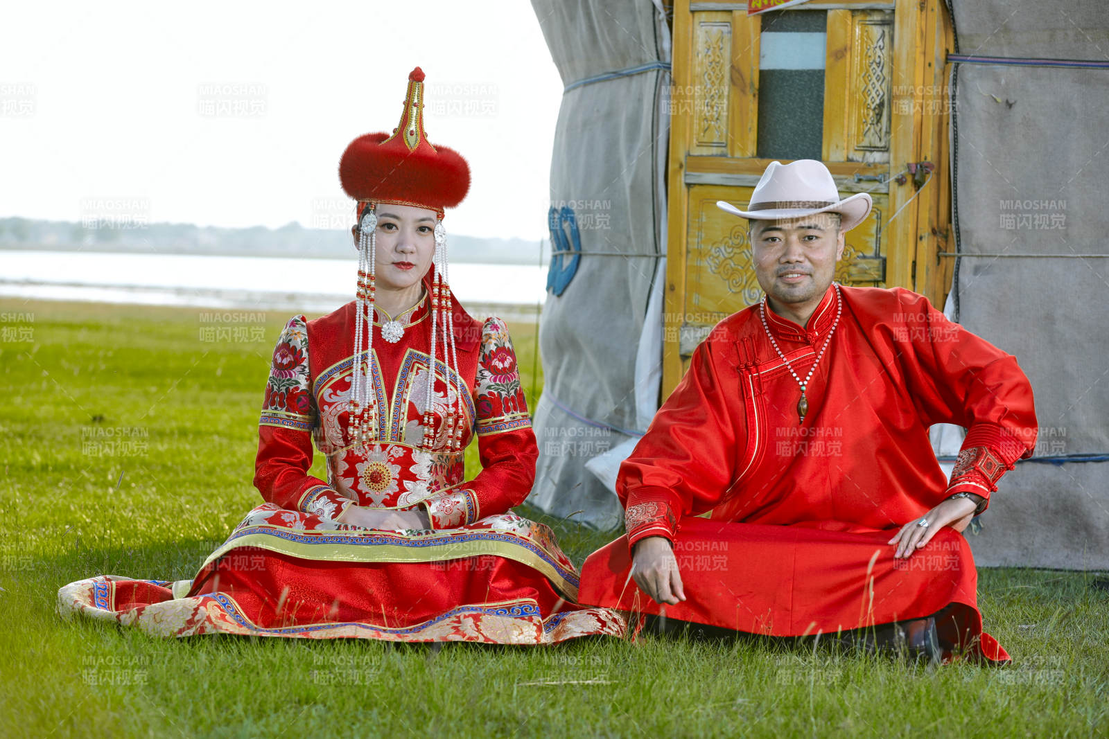 草原上蒙古包前穿蒙古族传统服饰的年轻夫妻图片