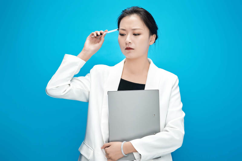 身穿西服拿着手机与文件夹的亚洲商务女士图片