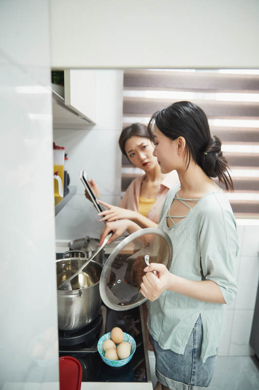 在厨房烹饪美食的亚洲闺蜜少女图片