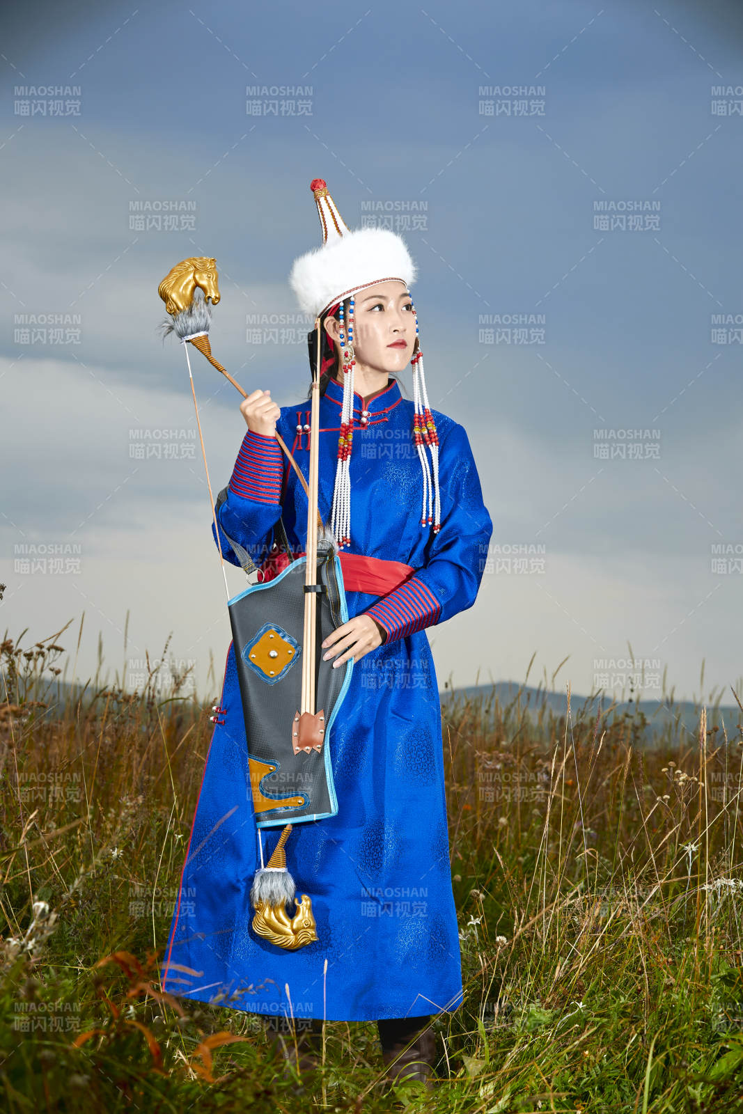 草原湖畔身穿蒙古族饰手持弓箭的蒙族少女图片