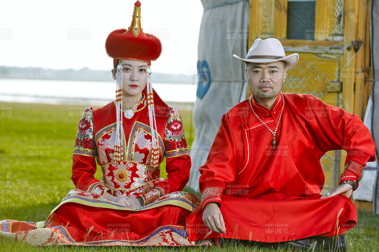 草原上蒙古包前穿蒙古族传统服饰的年轻夫妻图片