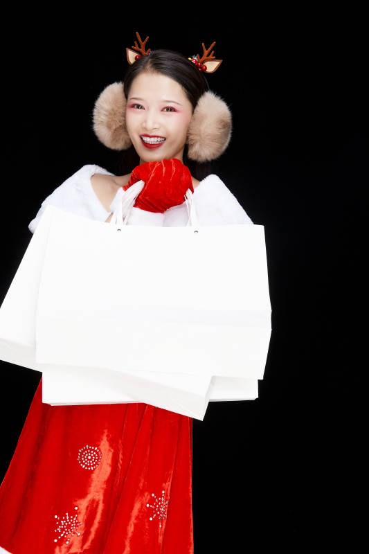 身穿圣诞服饰手提购物袋性感可爱的圣诞女郎图片