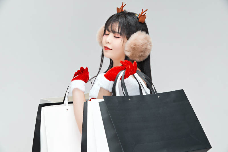 身穿圣诞服饰手提购物袋性感可爱的圣诞女郎图片