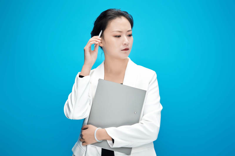 身穿西服拿着手机与文件夹的亚洲商务女士图片