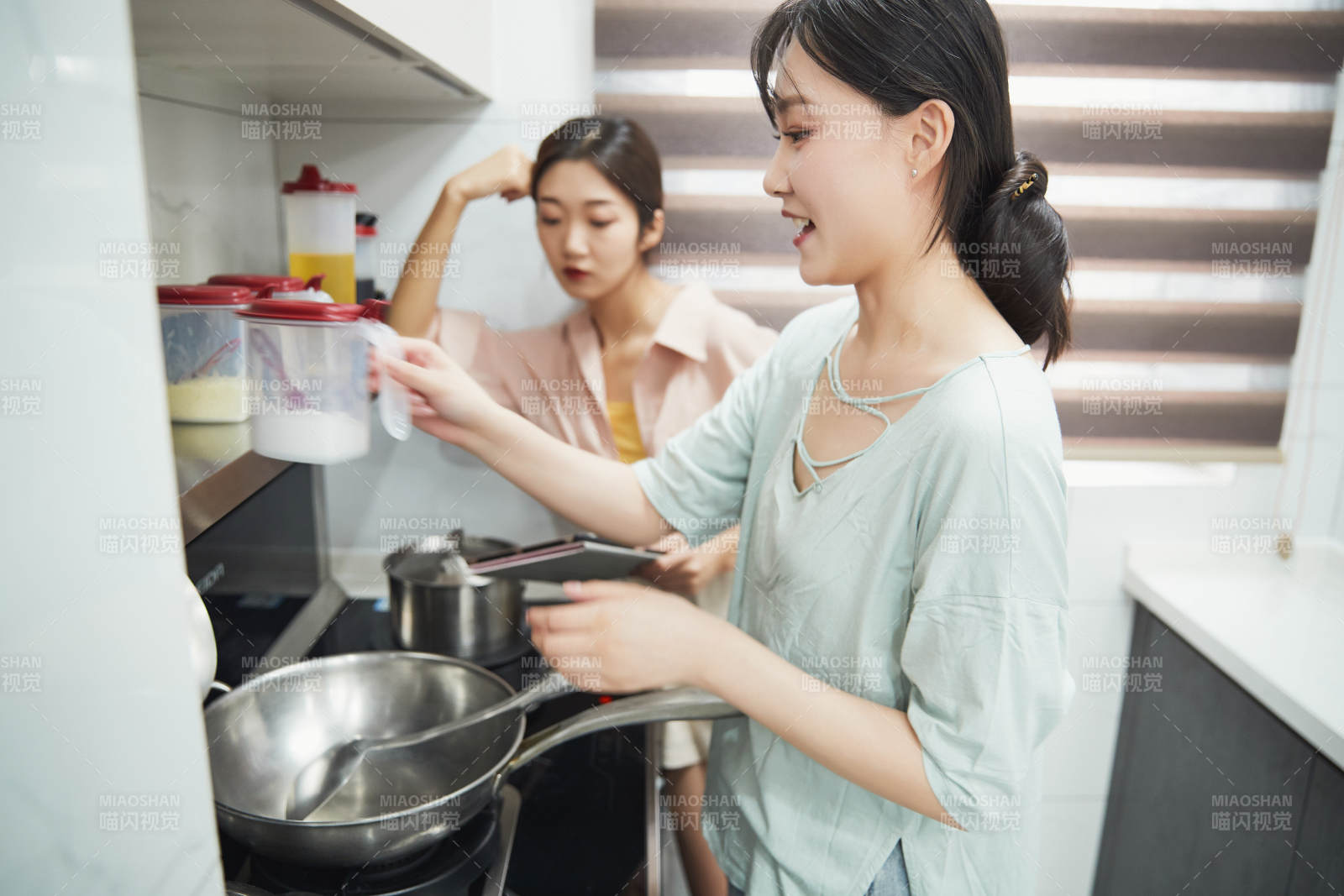 在厨房烹饪美食的亚洲闺蜜少女图片