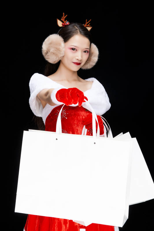 身穿圣诞服饰手提购物袋性感可爱的圣诞女郎图片