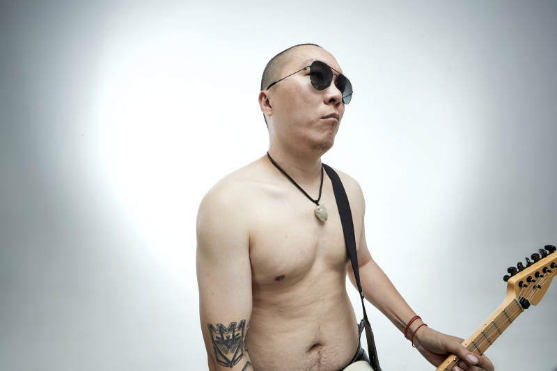 手持电吉他展示演奏的亚洲男性摇滚乐手人像图片