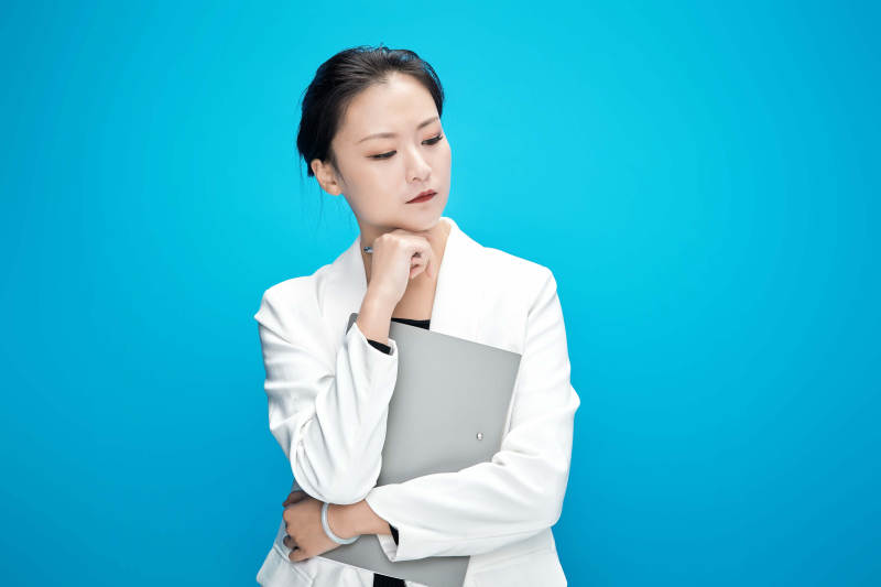 身穿西服拿着手机与文件夹的亚洲商务女士图片