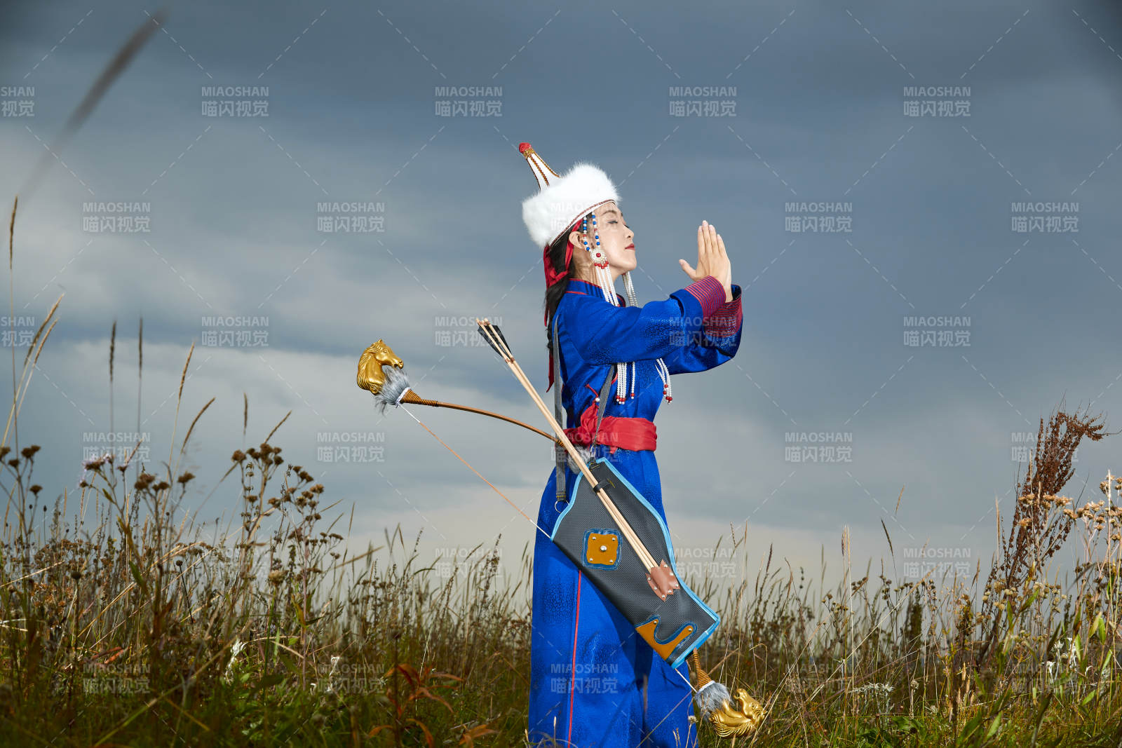 草原湖畔身穿蒙古族饰手持弓箭的蒙族少女图片