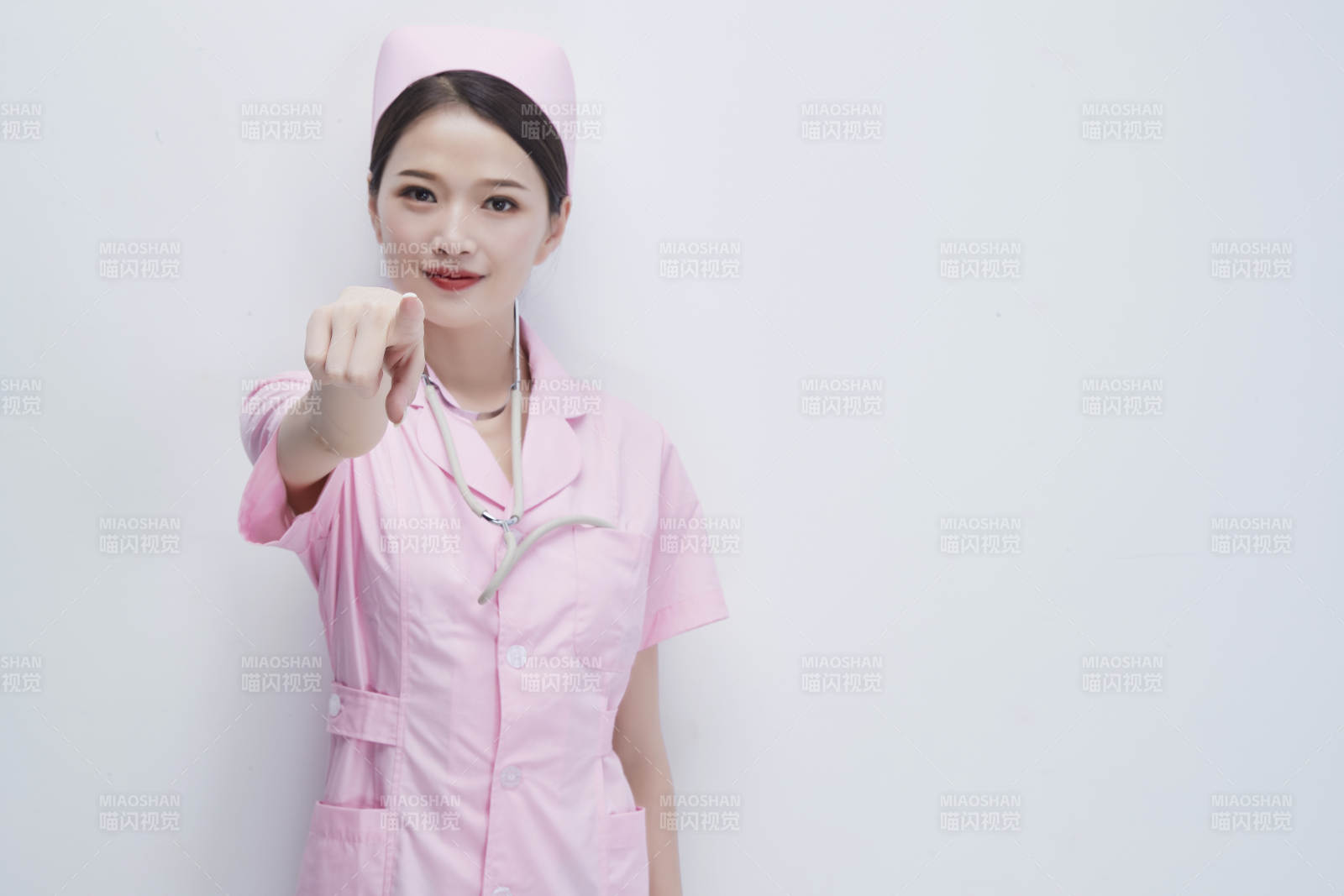 身穿粉色护士服佩戴听诊器的女性医护人员图片