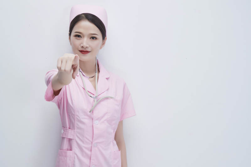 身穿粉色护士服佩戴听诊器的女性医护人员图片