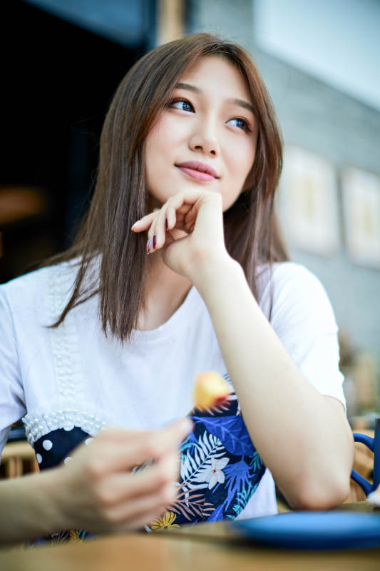 坐在咖啡图书馆吃东西的可爱少女图片