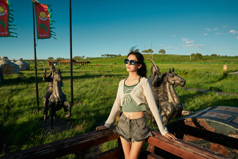 草原湿地公园游玩拍照的亚洲少女图片