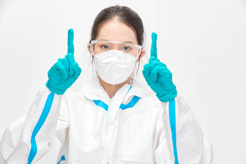 穿白色防护服佩戴护目镜口罩的女性医疗人员图片