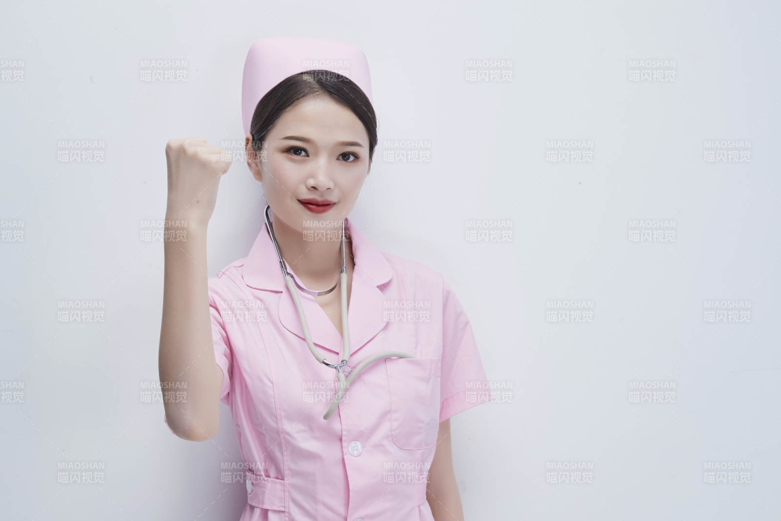 身穿粉色护士服佩戴听诊器的女性医护人员图片