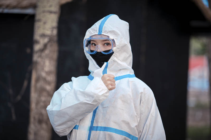 穿白色防护服佩戴护目镜口罩的女性防护人员图片