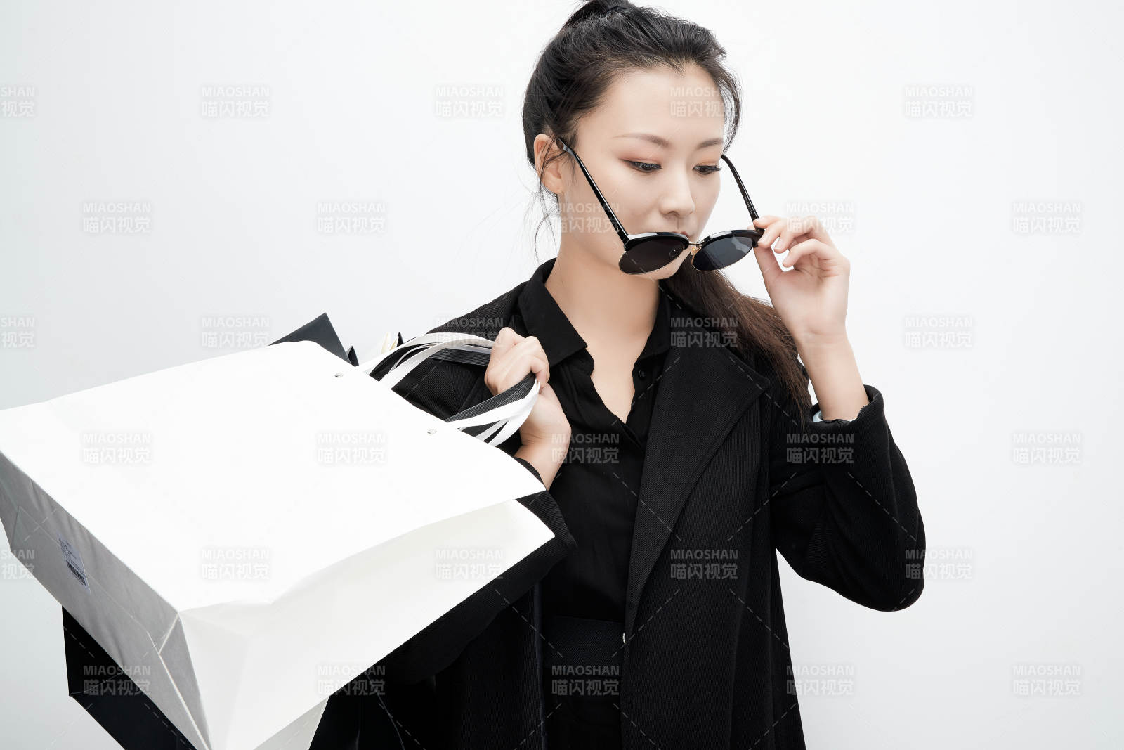 白色背景下手提购物袋时尚美丽的亚洲少女图片