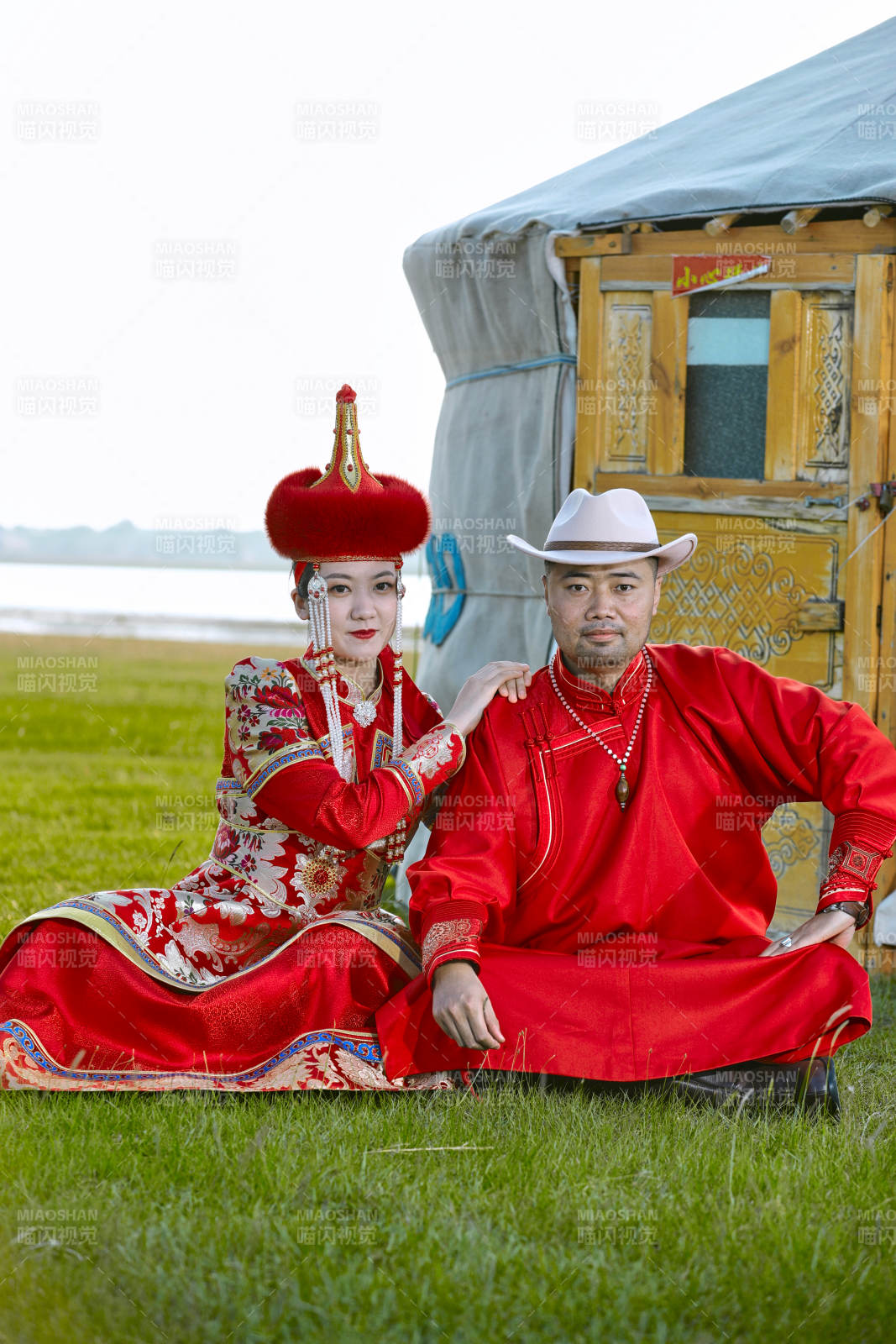 草原上蒙古包前穿蒙古族传统服饰的年轻夫妻图片