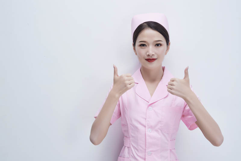 身穿粉色护士服佩戴听诊器的女性医护人员图片