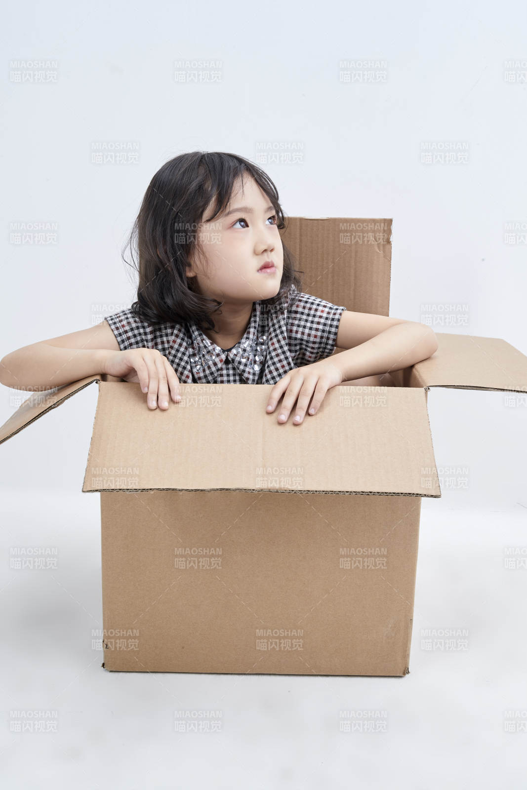 躲在纸箱中玩耍的调皮可爱亚洲小女孩儿童图片