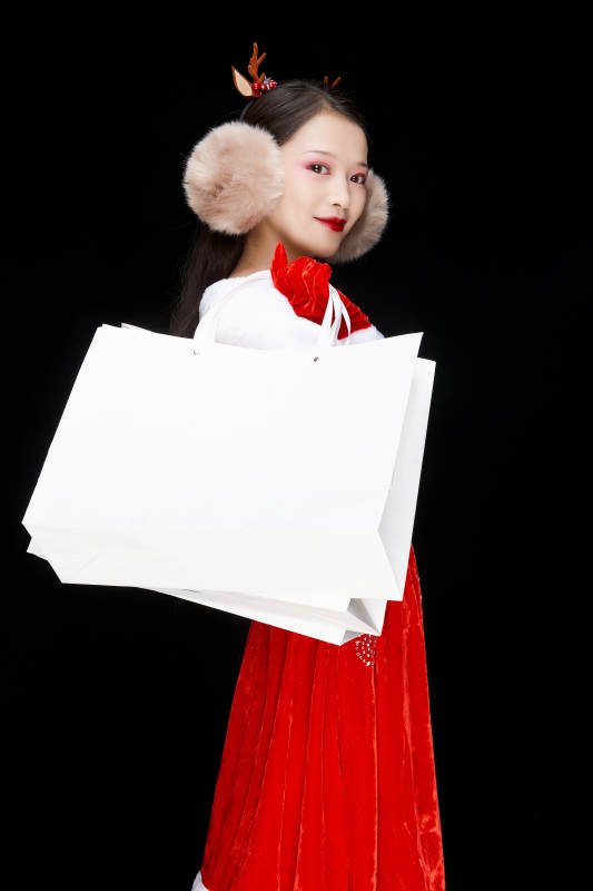 身穿圣诞服饰手提购物袋性感可爱的圣诞女郎图片