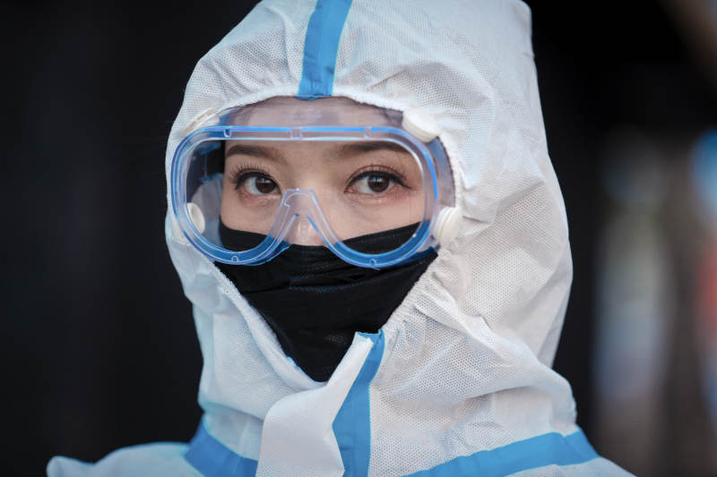 穿白色防护服佩戴护目镜口罩的女性防护人员图片