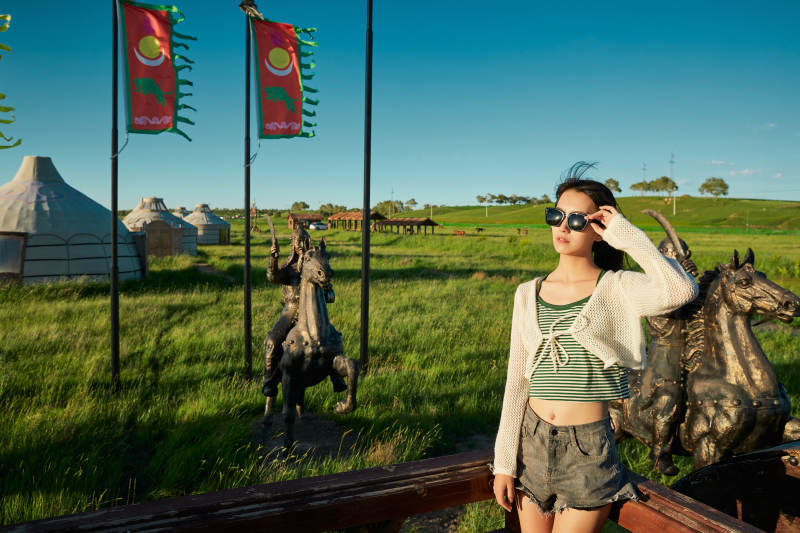 草原湿地公园游玩拍照的亚洲少女图片