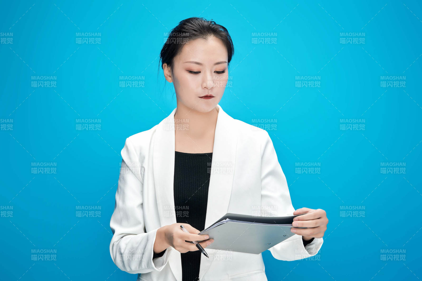 身穿西服拿着手机与文件夹的亚洲商务女士图片