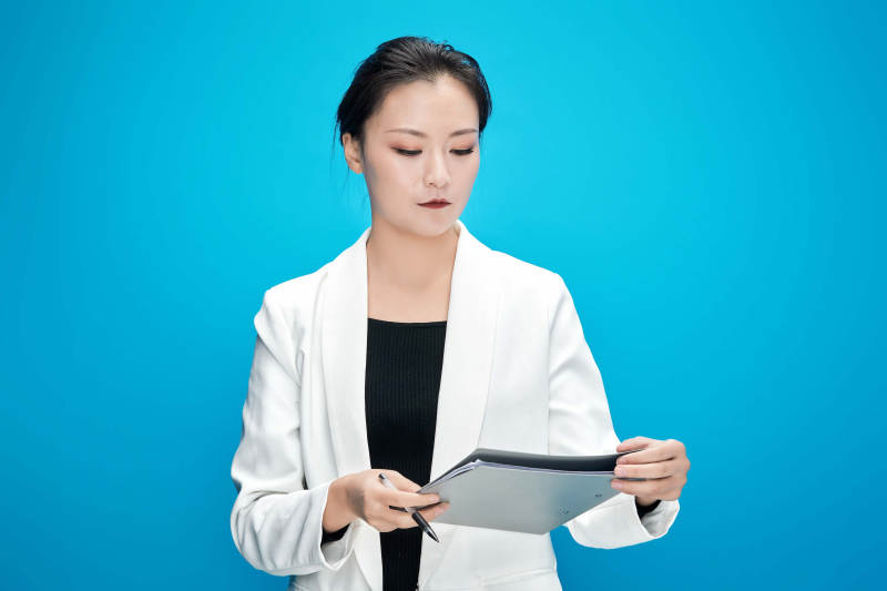 身穿西服拿着手机与文件夹的亚洲商务女士图片