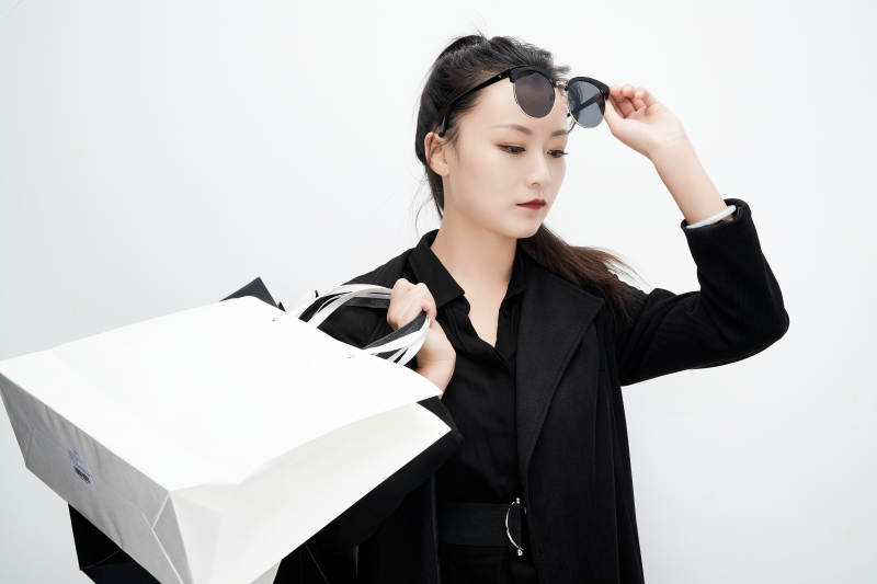 白色背景下手提购物袋时尚美丽的亚洲少女图片