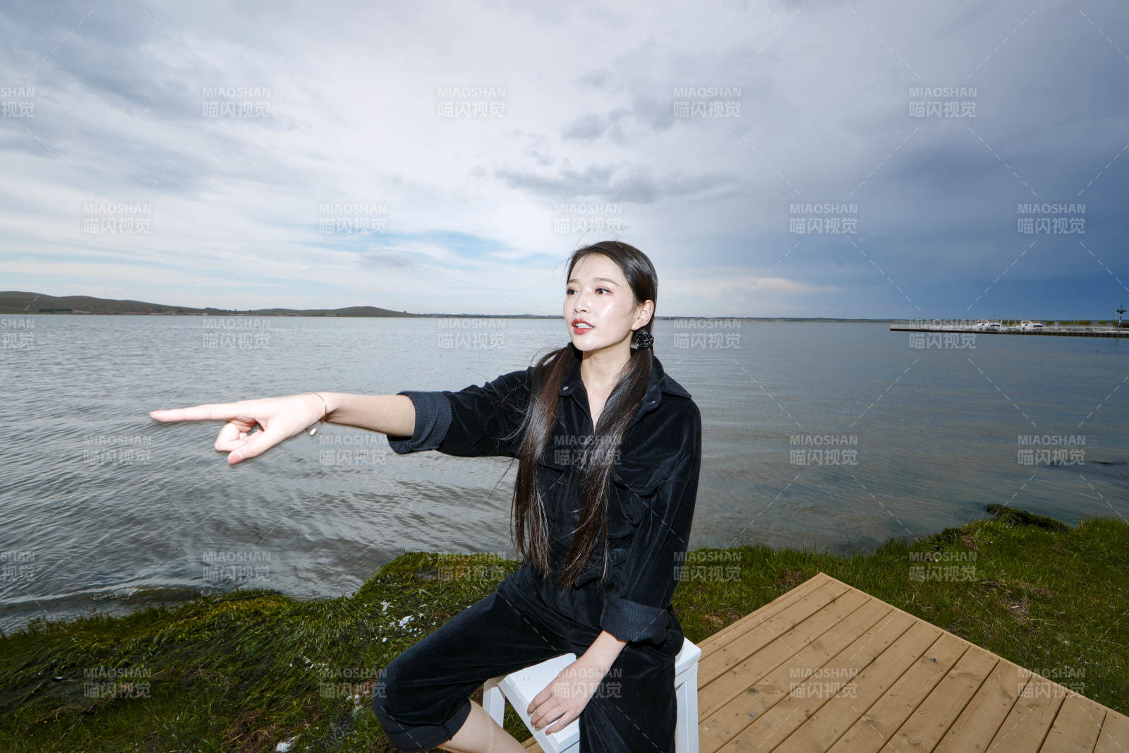 悠闲的坐在美丽湖岸码头的长发少女图片