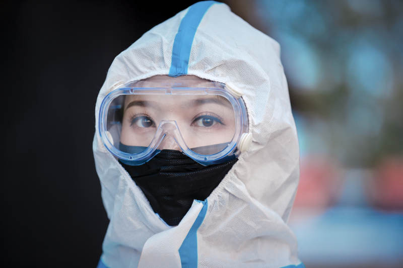 穿白色防护服佩戴护目镜口罩的女性防护人员图片