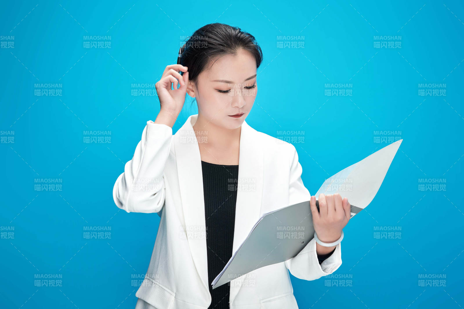 身穿西服拿着手机与文件夹的亚洲商务女士图片